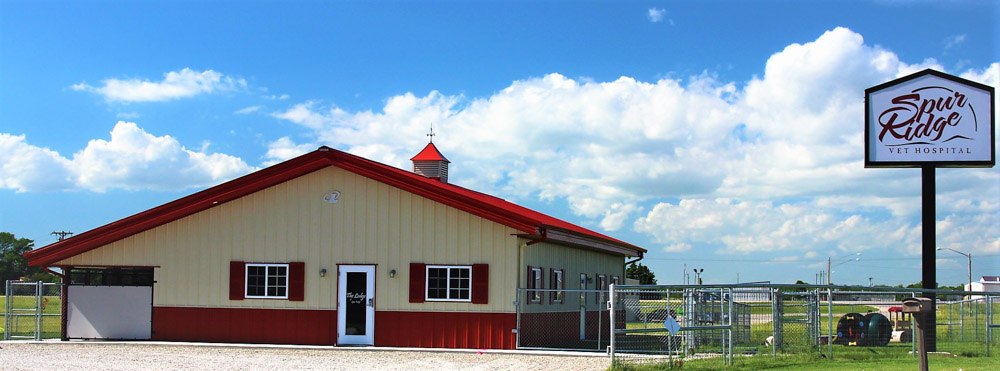 Red and tan metal building with fences